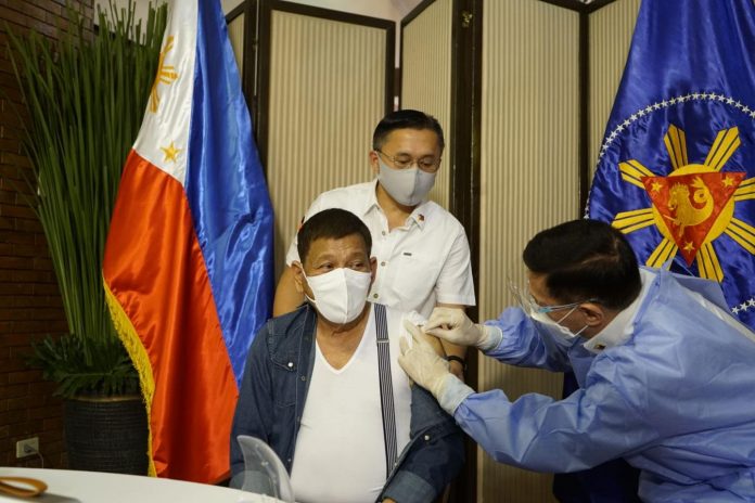 President Rodrigo Roa Duterte receives his first shot of COVID-19 vaccine, Monday, May 3, 2021. Senator Bong Go looks on as Health Secretary Francisco Duque III administers the vaccine. (Photo courtesy of Senator Bong Go)