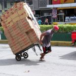 A delivery worker carefully pulls a trolley loaded with boxes of instant coffee to the Kadiwa Public Market along Congressional Avenue in Dasmariñas City, Cavite on Thursday (July 29, 2021). The worker made sure he is protected against Covid-19 by putting a cloth mask on. (PNA photo Gil Calinga)