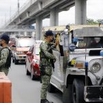 A police officer (right) inspects a passenger jeepney at the Marikina-Cainta, Rizal border checkpoint along Marcos Highway on Tuesday  (August 3, 2021). Authorities set up the checkpoint to ensure that only authorized persons outside their residence are allowed to travel. (PNA photo by Joey O. Razon)