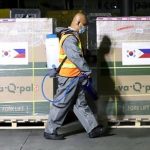 An airport worker disinfects the cargo of 539,430 doses of the AstraZeneca Covid-19 vaccine at the Ninoy Aquino International Airport Terminal 3 in Pasay City on Tuesday (Nov. 30, 2021). The jabs were donated by South Korea through the COVAX Facility. (PNA photo by Robert Oswald P. Alfiler)