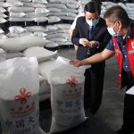 Chinese Ambassador Huang Xilian (left) shows the quality of the China-donated rice to Social Welfare and Development Director Emmanuel Privado at the DSWD National Resource Operations Center in Pasay on Wednesday (Dec. 22, 2021). At least 756,000 families are set to benefit from the rice donation. (Photo by Ben Briones)