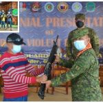 One of the 14 surrendering BIFF gunmen hands over his rifle to Brig. Gen. Eduardo Gubat (center), 603rd Infantry Brigade commander, during surrender rites held at the 57th Infantry Battalion headquarters in Upi, Maguindanao on Sunday (Dec. 5, 2021). The surrenderers also turned over (inset upper left) 12 high-powered firearms and five explosives. (Photo courtesy of 603rd IBde via PNA)