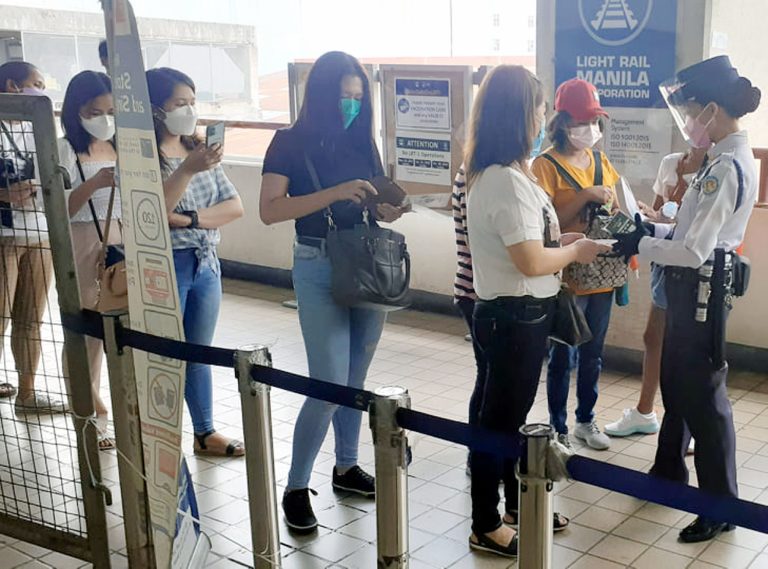 Passengers show their vaccination cards to a security guard (right) at the entrance of Light Rail Transit 1 (LRT1) in Baclaran station, Paranaque City on Wednesday (Jan. 19, 2022). The "no vaccination, no ride" policy has been implemented in all public transport to curb the spread of the COVID-19. (PNA photo by Ben Briones)
