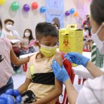 A boy and his sister look at the reformulated Pfizer Covid-19 jab being given to him by a health worker at the rollout of the jabs for the 5 to 11 age group at the SM City Taytay in Rizal on Tuesday (Feb. 15, 2022). The Department of Health said vaccinating children will allow them to go out, attend physical classes and restore social skills development and cognitive function affected by the pandemic. (PNA photo by Joey O. Razon)