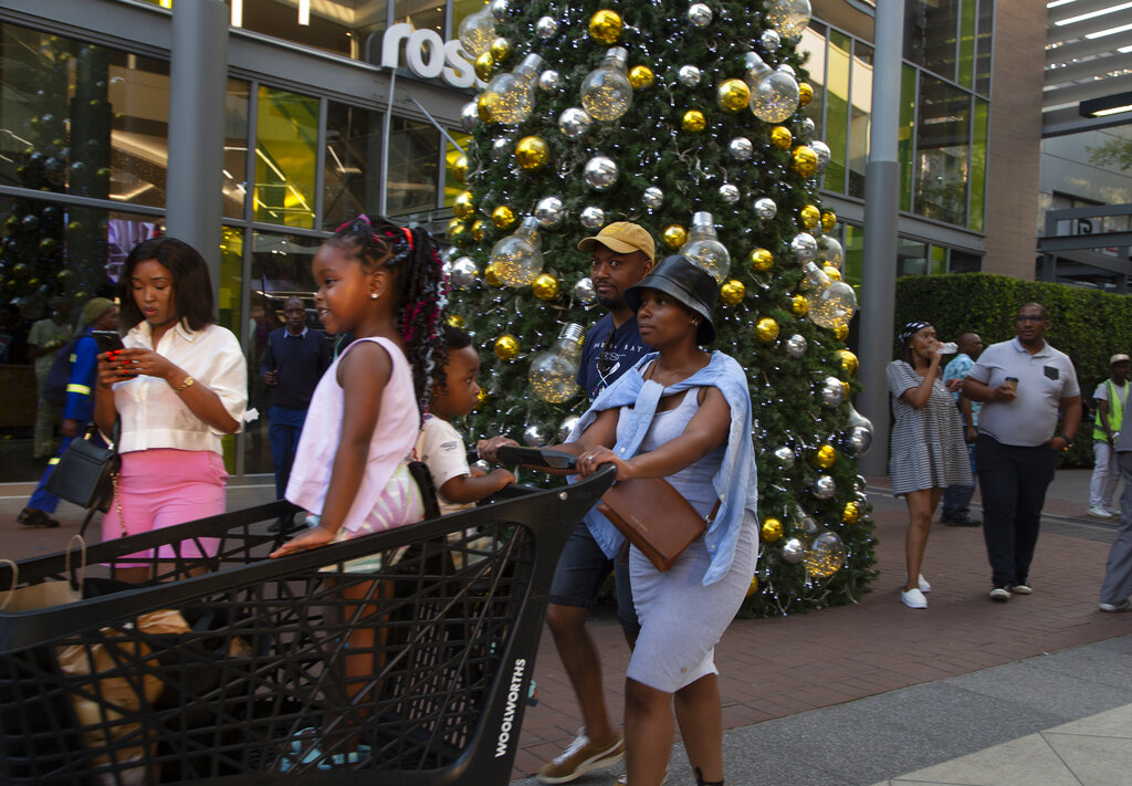 Shoppers pass a Christmas tree at the entrance to the Rosebank Shopping